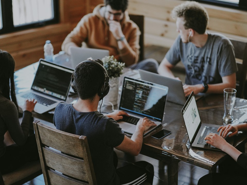 Engineers collaborating on laptops in a modern workspace